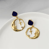 Gold-plated crescent moon and cross hoop earrings featuring a sparkling  cubic zirconia stone.
